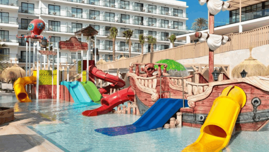 Piscina con toboganes y zona de juegos en hotel familiar en Málaga, ideal para vacaciones en familia.