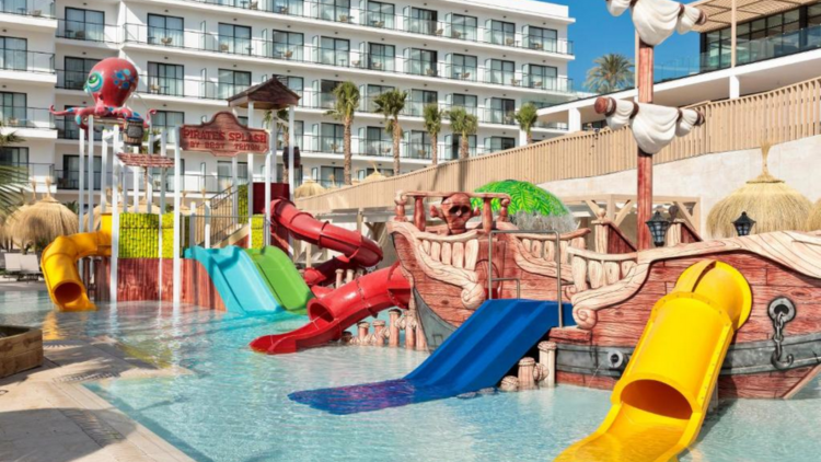 Portada de Facebook Foto Tecnología y Videojuegos Azul Neón(139) Piscina con toboganes y zona de juegos en hotel familiar en Málaga, ideal para vacaciones en familia.